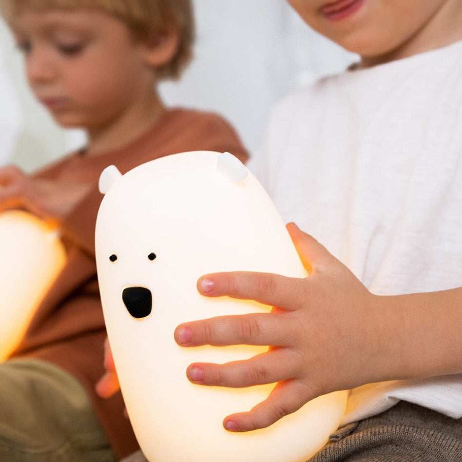 Children holding glowing polar bear-shaped night lights